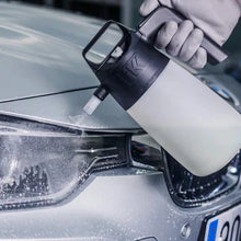 Load image into Gallery viewer, Person cleaning a car&#39;s headlight with a white spray bottle.
